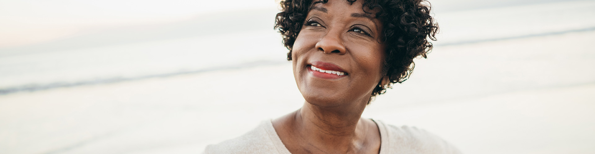 woman outside smiling looking up